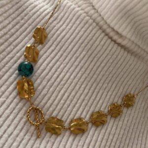 χειροποίητο κολιέ. Ανοξείδωτο ατσάλι σε χρυσό σφυριλατημένο κολιέ με γαλάζια πέρλα και ιδιαίτερο κούμωμα